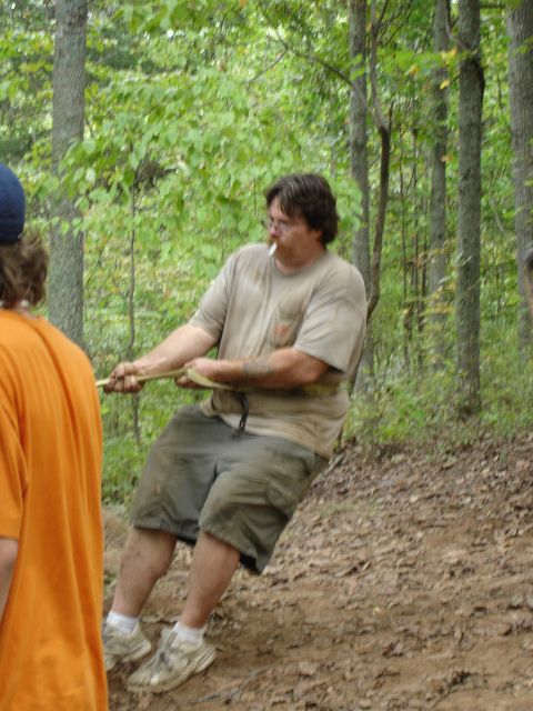 1996 Ford Bronco - A group of people are engaged in a tug-of-war competition in a forest setting.