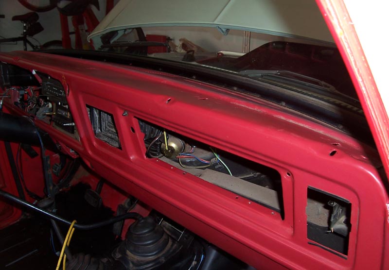 red dashboard with exposed wiring and vents, hood is up