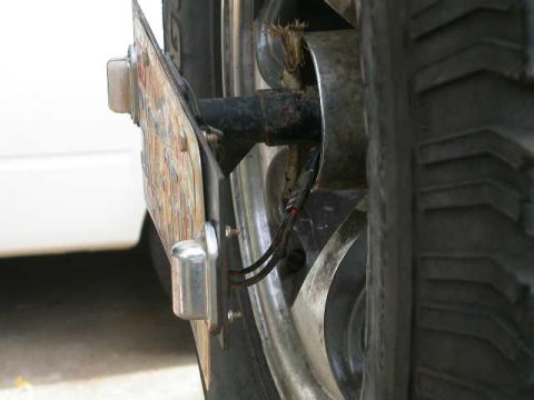1990 Ford Bronco - The rear license plate is mounted on a bracket, with wiring visible near the wheel hub.