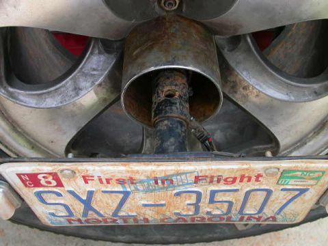 1990 Ford Bronco - License plate SXZ 3507 is mounted near the exhaust pipe of a vehicle.