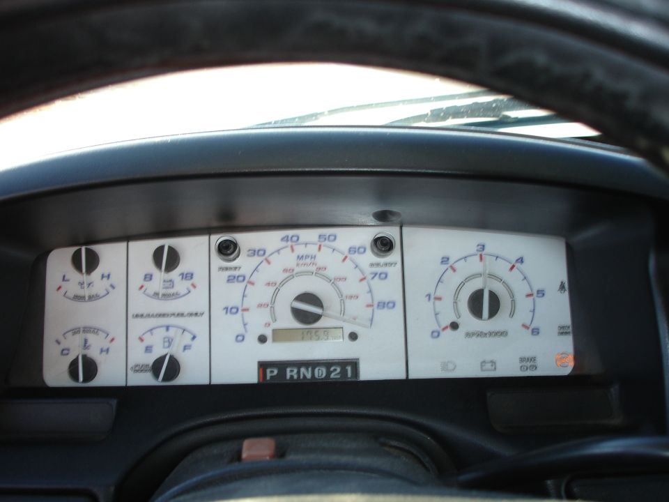 White-face truck gauge cluster seen through steering wheel, PRND21 gear display