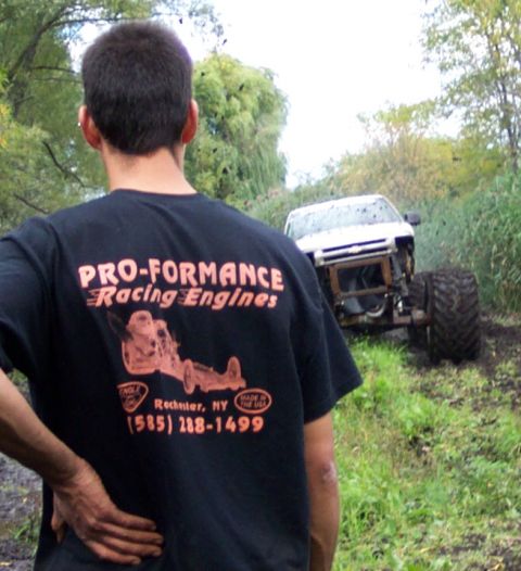 1978 Ford Bronco - A modified white vehicle with oversized tires is stuck in a muddy, grassy area.