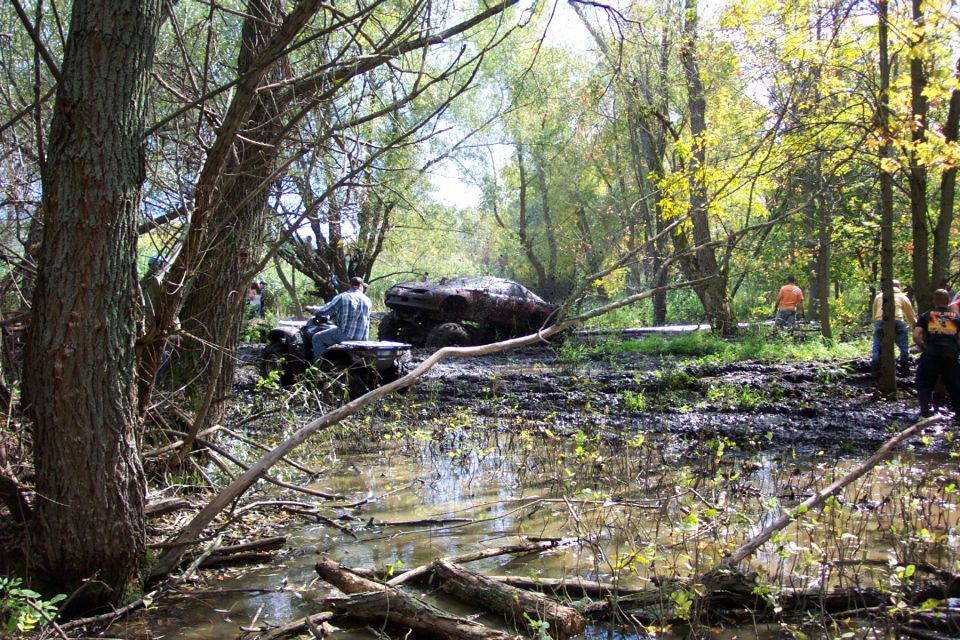 Muddy off-road vehicle stuck in water, driver seated
