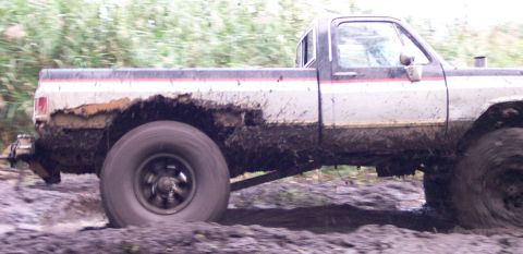 1978 Ford Bronco - This pickup truck is stuck in the mud, with its tires churning through the mire.
