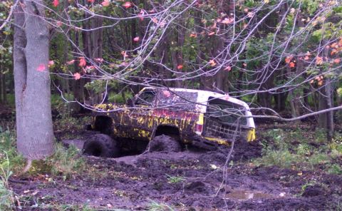 1978 Ford Bronco - This 1978 Ford Bronco is deeply stuck in mud and appears to be off-roading in a wooded area.