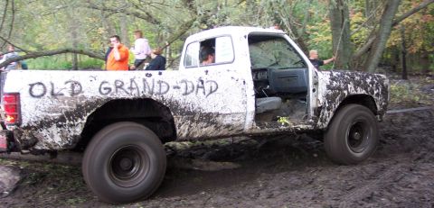 1978 Ford Bronco - This muddy pickup truck, labeled "OLD GRAND-DAD", navigates a challenging off-road course.
