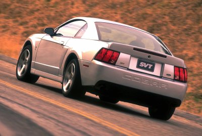 2003 Ford Mustang - Silver 2003 Ford Mustang SVT Cobra seen from the rear on a road.