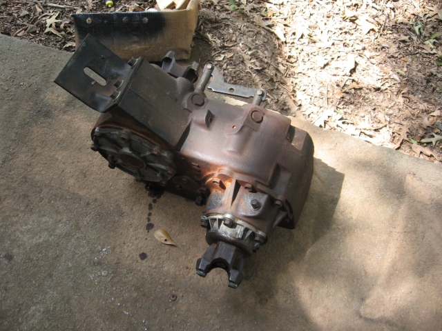 Rusty transfer case sitting on a concrete pad outdoors