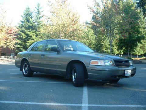 2000 Ford Crown Victoria - This 2000 Ford Crown Victoria sedan is parked outdoors with trees in the background.