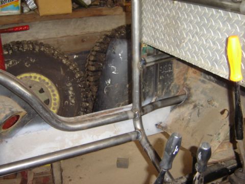 1992 Ford Bronco - Custom roll cage fabrication in progress on a vehicle chassis, with off-road tires in the background.