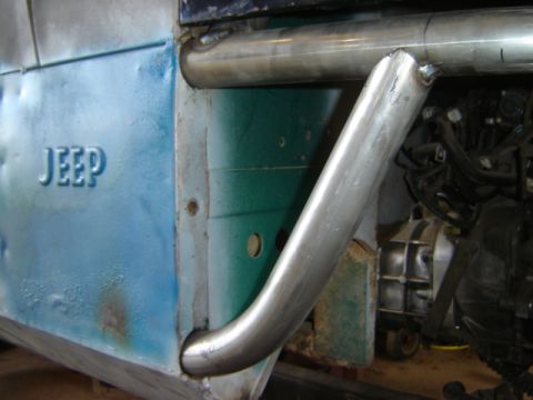 1992 Ford Bronco - Close-up view of a modified Jeep fender with visible roll cage and engine parts.
