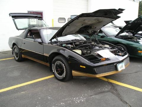 1994 Pontiac Trans Am - A black Pontiac Firebird with its hood and trunk open is parked next to another car.