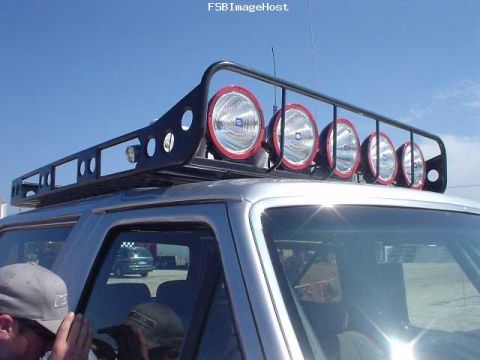 1996 Ford Bronco - A silver Ford Bronco is equipped with a large roof rack that holds six auxiliary lights.