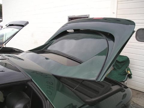 1994 Pontiac Trans Am - The rear of a dark green car is shown with the trunk open, revealing the interior storage area.