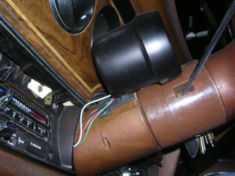 1975 Ford Ranchero - Close-up of a vehicle's interior, showing the dashboard, steering column, and wiring for an aftermarket gauge.