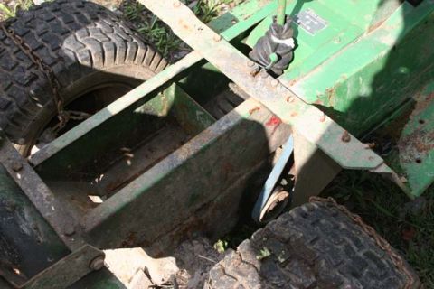 1987 Ford Bronco - Close-up of a rusty metal frame and tire from agricultural equipment.