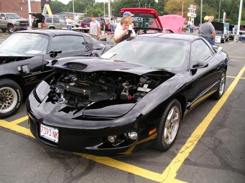 1994 Pontiac Trans Am - Two black Pontiac Firebird Trans Ams parked side-by-side at an outdoor car show.