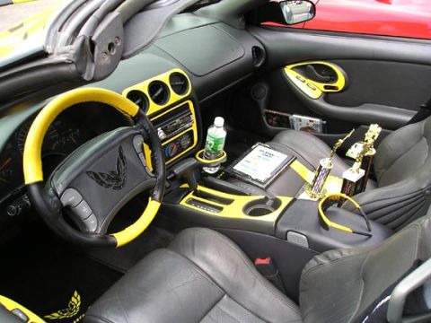 1994 Pontiac Trans Am - The interior of a 1994 Pontiac Trans Am features yellow accents on the steering wheel, dashboard, and door panels, along with trophies on t…
