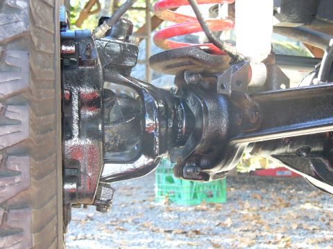 1978 Ford Bronco - Detail shot of a vehicle's front axle assembly, including suspension and braking components.