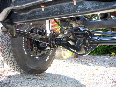 1978 Ford Bronco - Close-up of a vehicle's rear axle and suspension system, showing tire and shock.