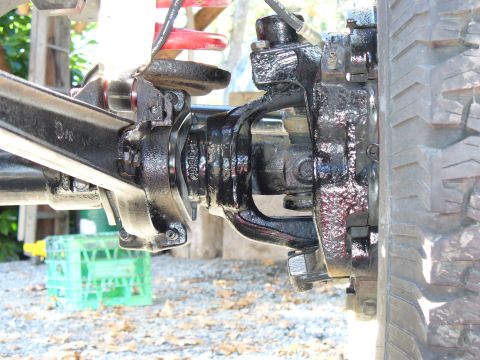 1978 Ford Bronco - Close-up view of a vehicle's front axle assembly, showing painted components and a portion of the tire.