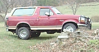 1994 Ford Bronco - This red Ford Bronco has a two-tone paint scheme with a tan removable top.