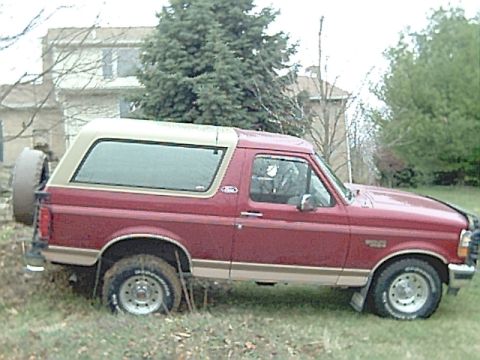 1994 Ford Bronco - This 1994 Ford Bronco features a two-tone paint scheme with a removable tan top and a spare tire carrier on the tailgate.