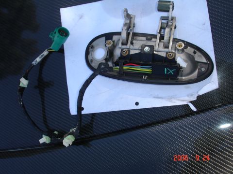 1993 Ford Taurus - Close-up of a car door handle mechanism and its electrical connector, likely for a power lock or window.