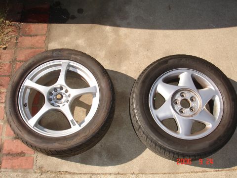 1993 Ford Taurus - Two different car wheels and tires are shown resting on a concrete surface.