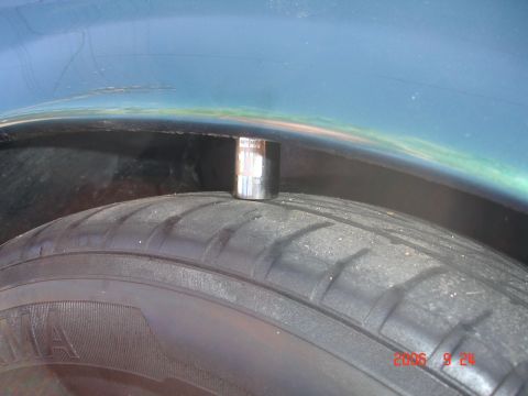 1993 Ford Taurus - A socket wrench is placed on a tire, near the wheel well of a vehicle.