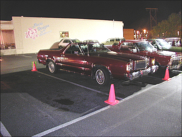 Maroon Ford Ranchero coupe-utility on wire wheels in a night parking lot