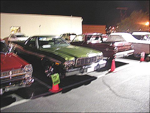 1967 Ford Ranchero - A green 1972 Ford Ranchero is parked next to a red car, with other vehicles in the background.