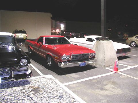 1967 Ford Ranchero - A red 1972 Ford Ranchero is parked next to other vehicles in a lot at night.