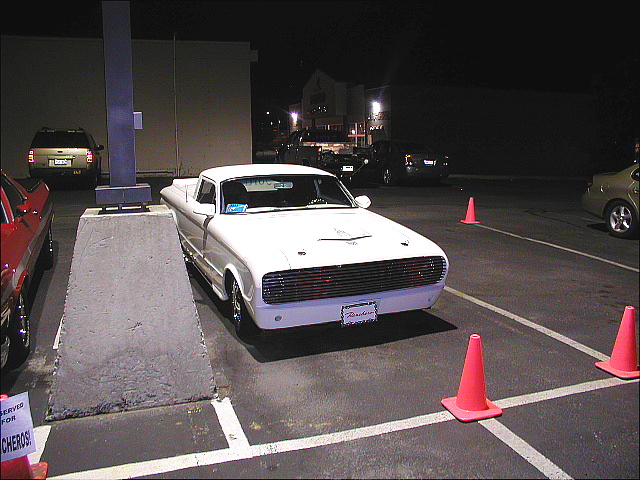 White Ford Ranchero car-pickup parked at night surrounded by orange cones