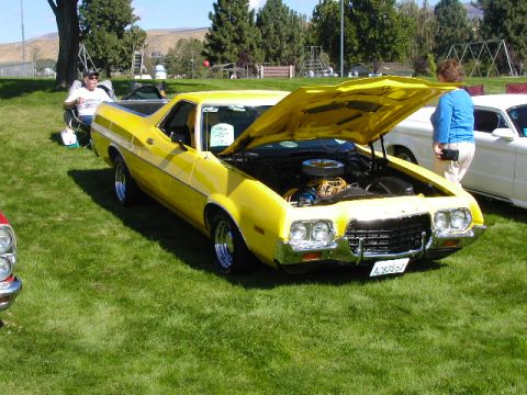 1967 Ford Ranchero - This yellow Ford Ranchero, likely a 1972 model, is displayed with its hood open, revealing the engine. A license plate is visible on the fr…