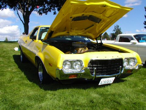 1967 Ford Ranchero - A yellow 1972 Ford Ranchero is displayed with its hood open, parked on a grassy field next to another vehicle.