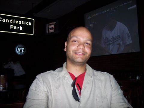 1995 Ford Probe - A man smiles for the camera in a dimly lit room with a baseball game projected on a screen behind him.