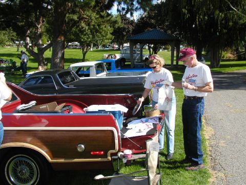 1967 Ford Ranchero - People gather around vehicles at an outdoor event, possibly a car show.