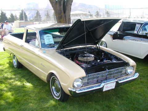 1967 Ford Ranchero - Tan 1960 Ford Ranchero pickup truck with hood open, parked on grass at an outdoor event.