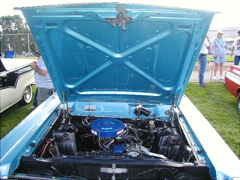 1967 Ford Ranchero - The engine bay of a light blue 1967 Ford Ranchero, a blue air cleaner and V8 engine, is displayed with the hood open.