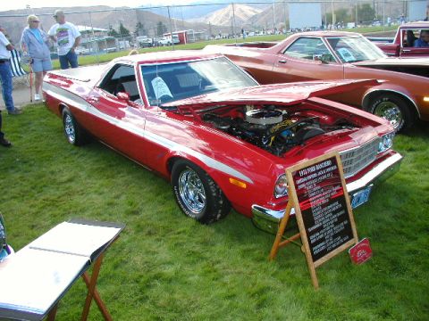 1967 Ford Ranchero - A red 1974 Ford Ranchero is displayed with its hood open, revealing the engine, next to another vehicle at a car show.