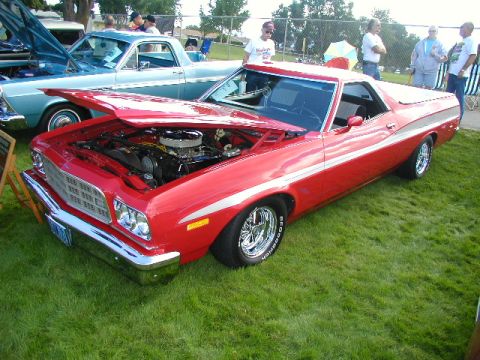 1967 Ford Ranchero - Red 1972 Ford Ranchero at a car show, hood open to reveal engine. Another Ranchero is visible behind it.