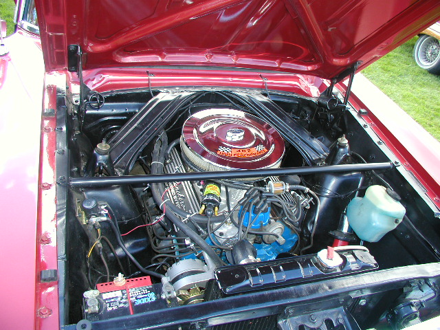 Open hood showing a Ford V8 engine with chrome air cleaner and blue valve covers