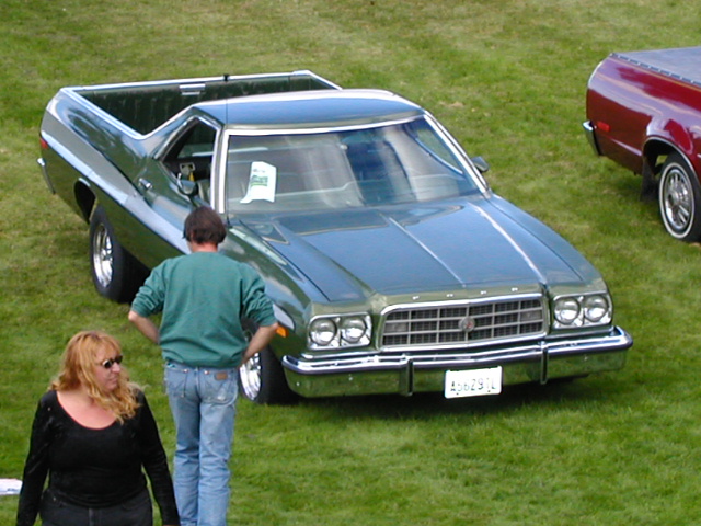 Green 1970s Ford Ranchero coupe-utility with cargo bed at a car show on grass