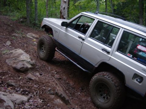 1991 Ford Bronco - This Jeep Cherokee XJ is navigating a challenging off-road course with large tires and lifted suspension.