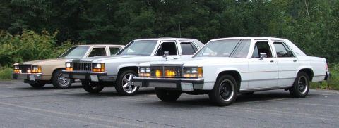 1985 Ford LTD Crown Victoria - Three 1985 Ford Crown Victoria LTD sedans are parked side-by-side on a paved surface.