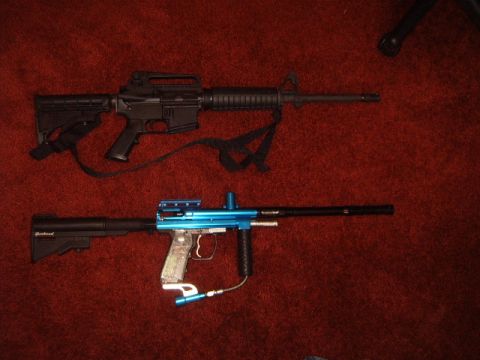 1988 Ford Bronco - Two firearms, a black rifle and a blue paintball gun, are displayed on a red carpet.