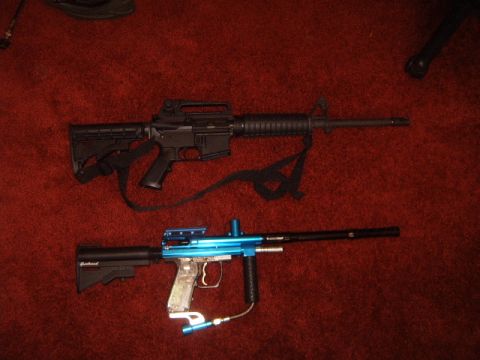 1988 Ford Bronco - Two firearms, a black rifle and a blue paintball gun, are displayed on a red carpeted surface.