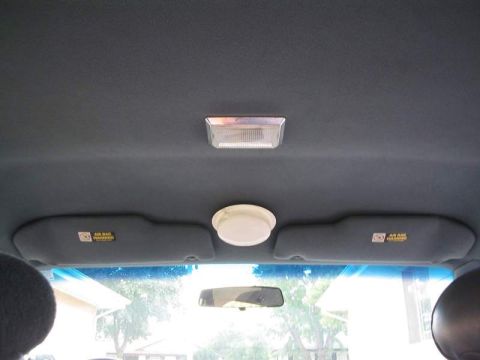 1998 Ford Crown Victoria - The interior ceiling of a car shows two sun visors and two lights, lights.