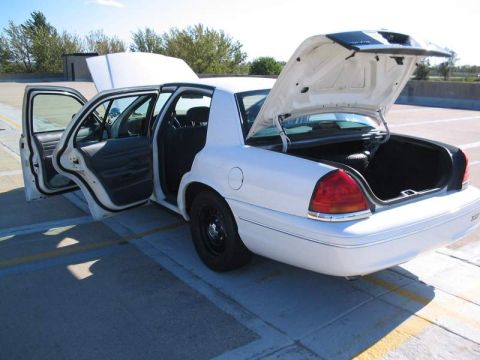 1998 Ford Crown Victoria - This white 1998 Ford Crown Victoria is viewed from the rear with all doors and the trunk open.